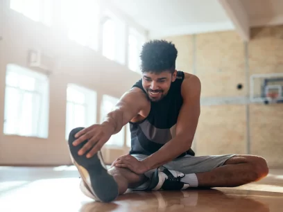 Male stretching hamstring muscles after doing sports and exercise to avoid sport injuries and muscular strains, overuse and pain.