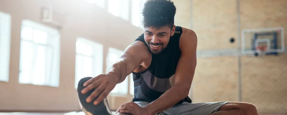 Male stretching hamstring muscles after doing sports and exercise to avoid sport injuries and muscular strains, overuse and pain.