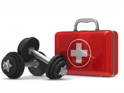 First aid kit with dumbbells on the side representing safety and injury prevention when exercising at the gym.
